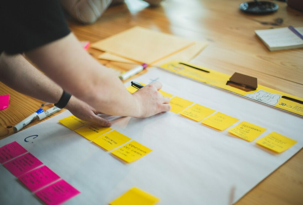 person working on a whiteboard with sticky notes