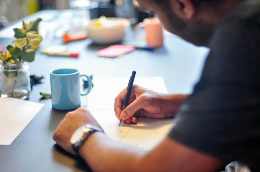 close-up of a person writing in a notebook