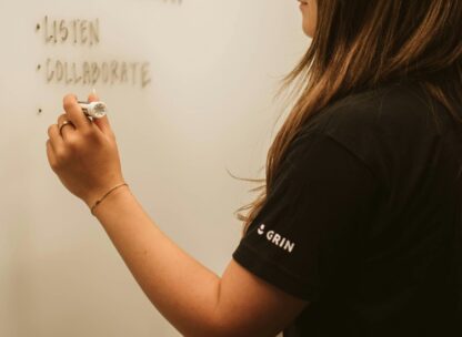 A woman writing on a whiteboard