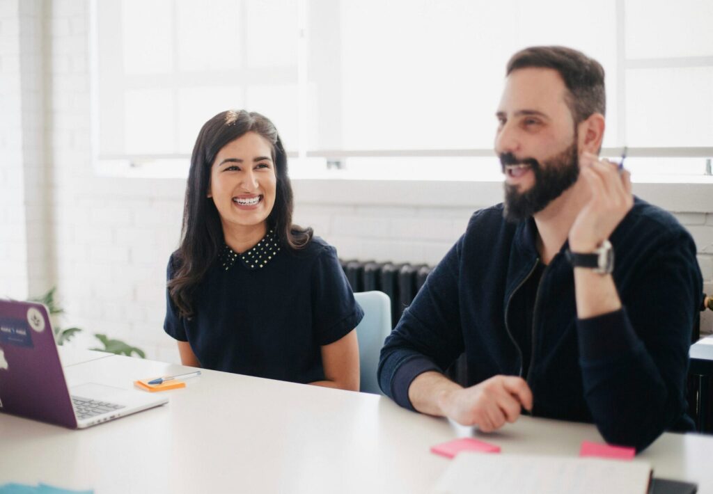 A man and a woman sitting at a desk talking