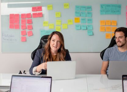 A professional woman working in front of a wall full of sticky notes