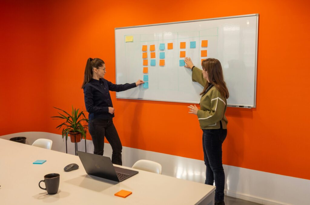 two women presenting at a whiteboard